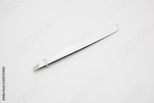 tools for eyelash extension and eyebrow design. cosmetic tweezers in silver color on a white background