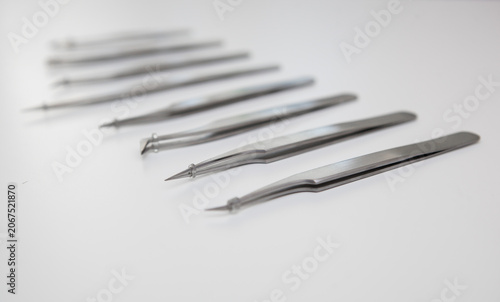 tools for eyelash extension and eyebrow design. cosmetic tweezers in silver color on a white background