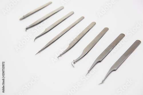 tools for eyelash extension and eyebrow design. cosmetic tweezers in silver color on a white background