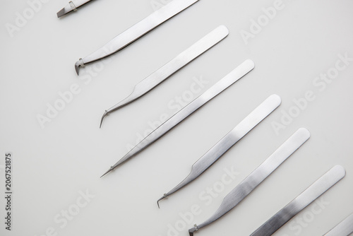tools for eyelash extension and eyebrow design. cosmetic tweezers in silver color on a white background