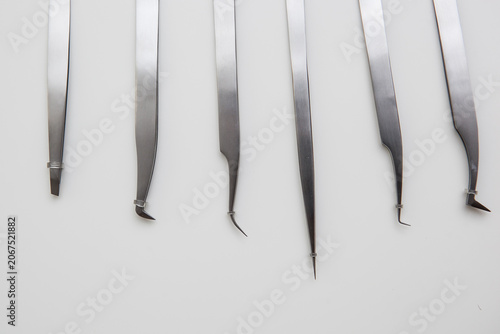 tools for eyelash extension and eyebrow design. cosmetic tweezers in silver color on a white background