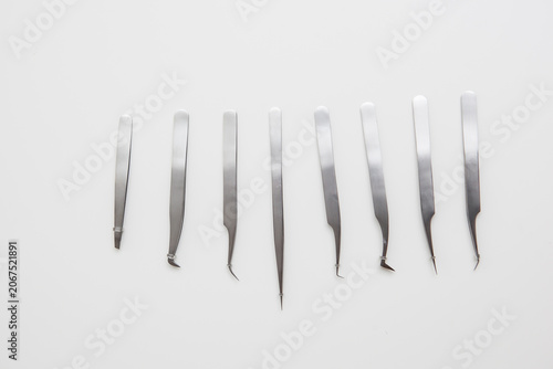 tools for eyelash extension and eyebrow design. cosmetic tweezers in silver color on a white background