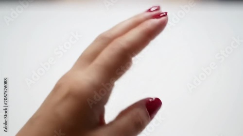 Close-up of hand with professional red nail polish.