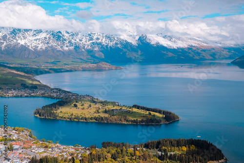 Queenstown, New Zealand: Panoramic horizontal travel view from Bob's Peak over Lake Wakatipu peninsula, city and snow-tipped Southern Alps mountains.