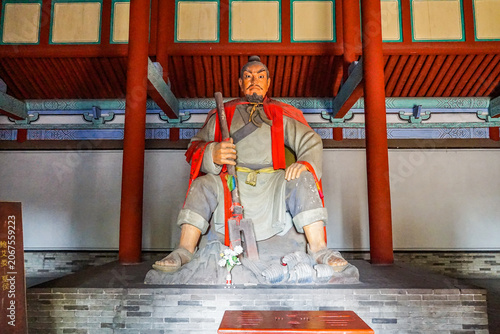 Fotografie Seated Warrior Deity Statue in Traditional Chinese Temple Hall