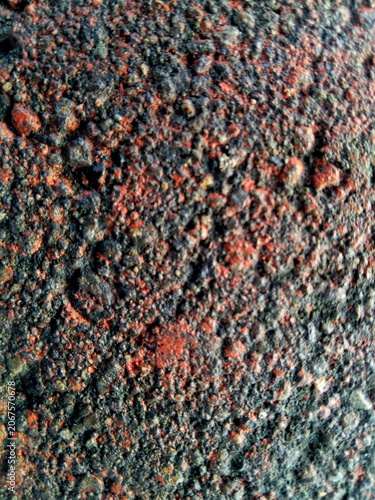 Close up of red and black rough asphalt texture with small stones 
