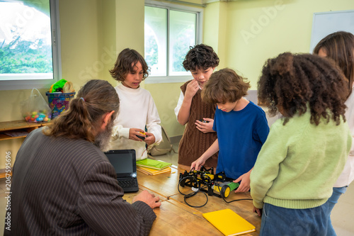 фотографія Curious elementary students learning and concentrating to build small robot with