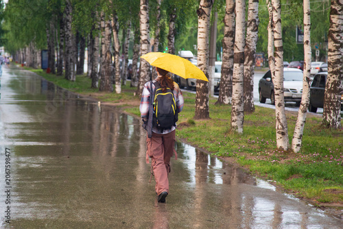 Fotografía Storm, heavy rain in the city.People in the rain with an umbrella
