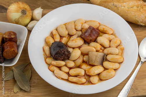 Fabada asturiana e ingrediente sobre una mesa rústica