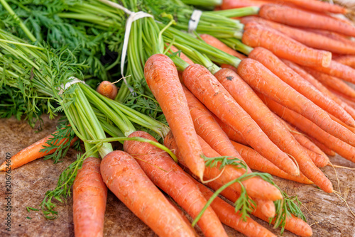 Fresh, vibrant orange carrots with leafy green tops