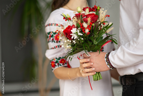 bride and groom in embroidered Ukrainian dresses. A beautiful bouquet