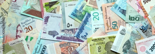 Big amount of money bills of various currencies. Assortment background of international cash