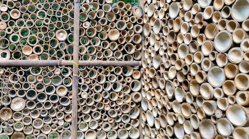фотографія An arrangement of bamboo stem sections cut crosswise and stacked tightly in a vertical orientation, creating a decorative wall structure or partition
