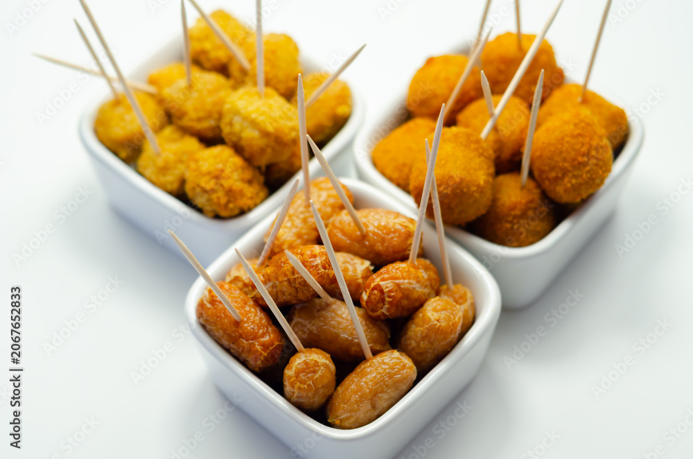 Fototapeta premium Golden, crispy snacks rest in white bowls
