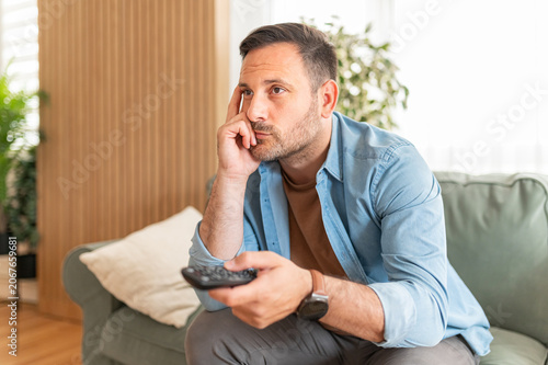 Tableau sur toile Man feeling boredom and indifference while relaxing on a comfortable piece of fu