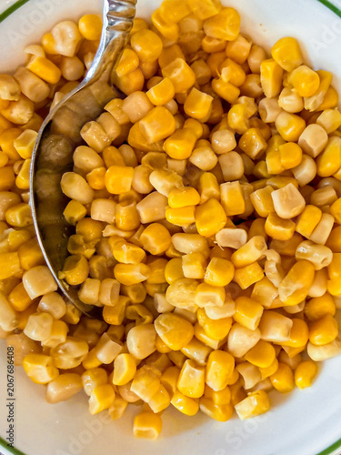 Bowl of Sweet Corn Kernels with Serving Spoon