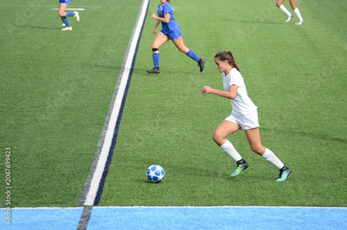 Female soccer player advancing the ball in the middle of the field