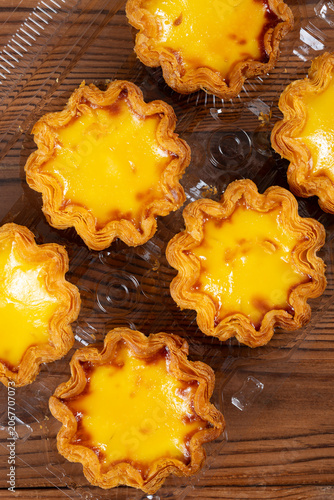 top view portuguese egg tarts on a wooden table at vertical composition