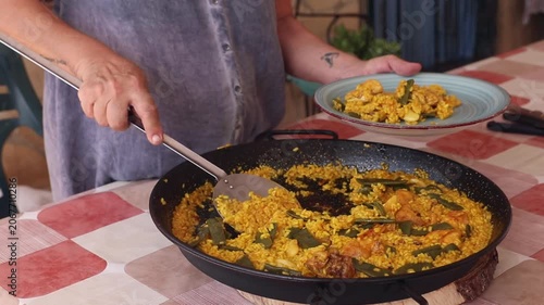 Mujer sirviendo una paella valenciana 