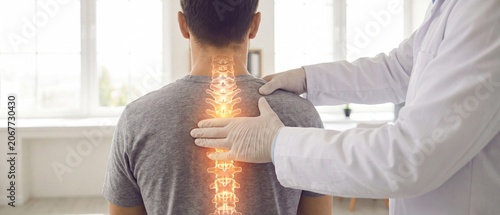 Chiropractor performing precise spinal adjustment on patient’s back with glowing vertebrae overlay, professional medical treatment.