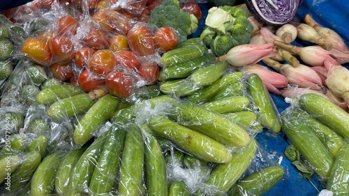 Variety of fresh organic vegetables wrapped in plastic bags for sale at a local traditional market