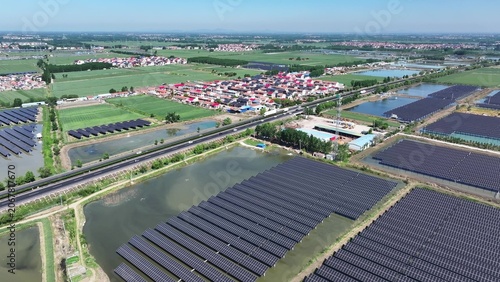 Obraz na plátně Aerial view of large-scale photovoltaic power station adjacent to rural farmland
