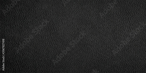 Close-up of a textured black leather surface, showing its grain and subtle variations in light and shadow.