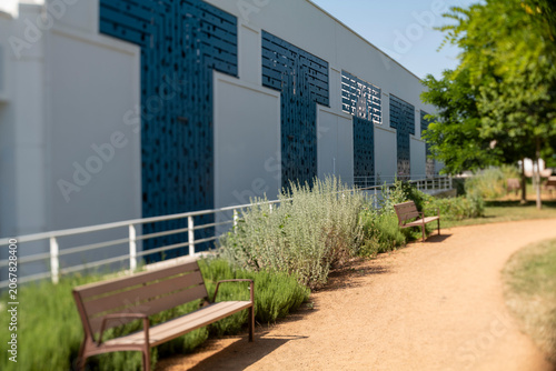 Outdoor Park Pathway with Benches and Modern Building Facade