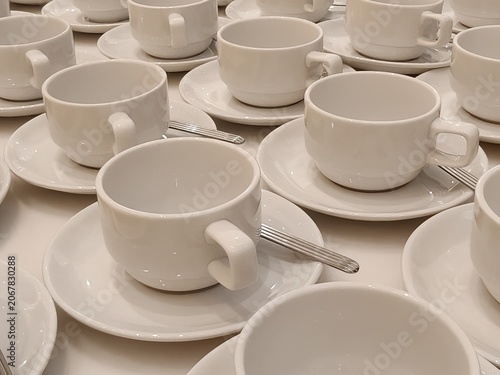 Empty White Teacups with Silver Spoons on Matching Saucers