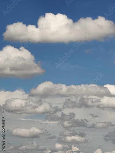 Layered Cumulus Clouds Drifting Across Blue Summer Sky