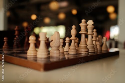 Strategic Game Concept Featuring Sharp Focus on Wooden Chess Pieces in a Relaxed Indoor Setting