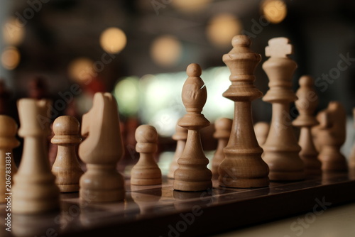 Strategic Game Concept Featuring Sharp Focus on Wooden Chess Pieces in a Relaxed Indoor Setting