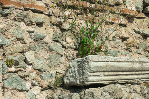 Ancient carved stone fragment among archaeological ruins and weathered masonry at historic heritage site