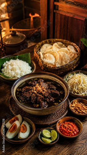 Traditional rawon meal spread with black beef soup, rice, crackers, sambal, and egg .generative AI