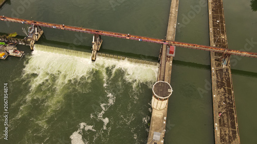 Aerial view of the weir on the Seine river with concrete structures and flowing water in Chartrettes, Ile-de-France, France.