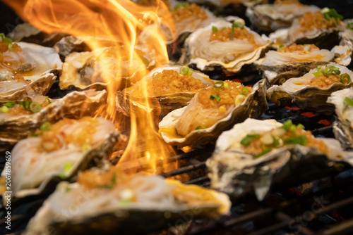 Cuadro en lienzo Grilled oyster with garlic butter, scallion and crispy topping on hot flame, sav