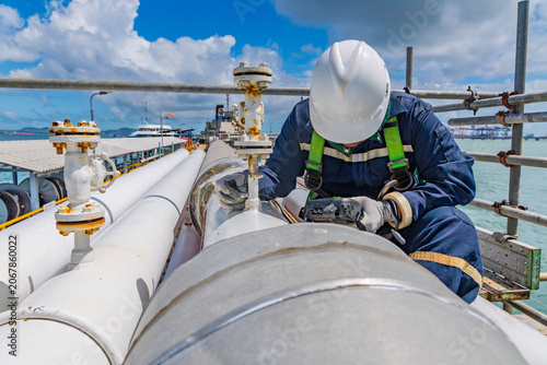 Male worker inspection and measurement thickness pipeline oil and gas at check record pipeline