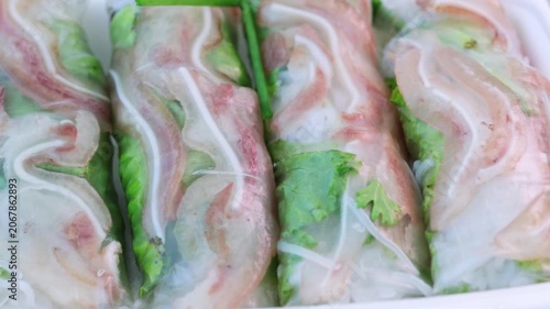 Freshly made vietnamese spring rolls filled with pork, vermicelli, and vegetables rotating on a platter. This healthy and authentic asian appetizer is a popular dish from southeast asia