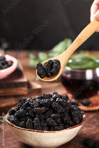 Obraz na płótnie Dried Black Mulberries in Wooden Spoon and Bowl