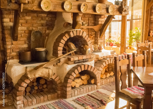 Fotografie Rustic brick oven setup in a cozy kitchen with wooden accents and warm lighting