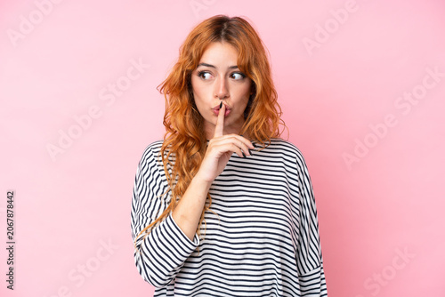 Tableau sur toile Young caucasian woman isolated on pink background showing a sign of silence gest