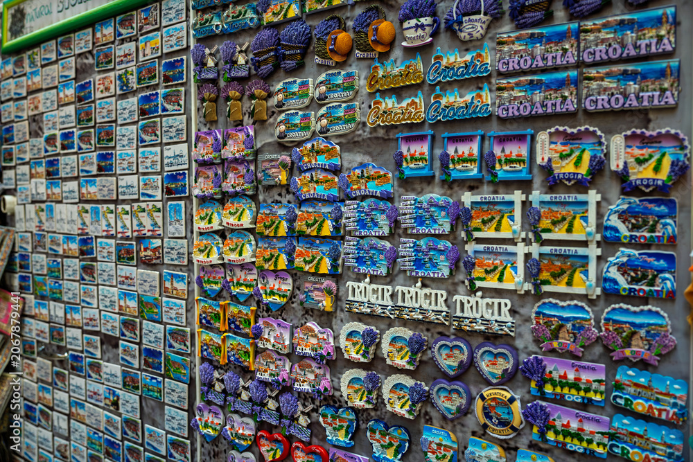 Fototapeta premium Colorful souvenir magnets featuring Croatia and Trogir landmarks displayed at a local gift shop