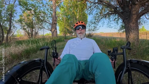 Senior cyclist is riding a full suspension recumbent tricycle on a rough gravel trail in northern Colorado - Kyger Open Space
