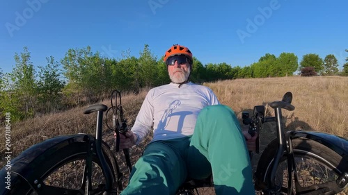 Senior cyclist is riding a full suspension recumbent tricycle on a rough gravel trail in northern Colorado - Kyger Open Space