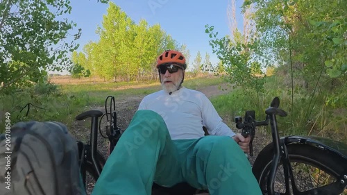 Senior cyclist is riding a full suspension recumbent tricycle on a rough gravel trail in northern Colorado - Kyger Open Space