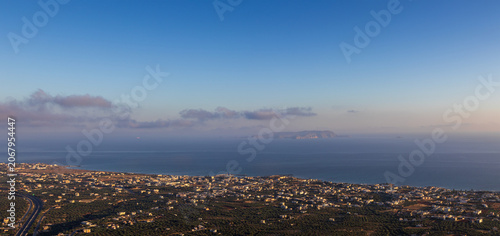 High angle panoramic view of Kato Gouves coastal town and Dia island in the Mediterranean sea, shot from Mount Edheri in Crete, Greece during early morning
