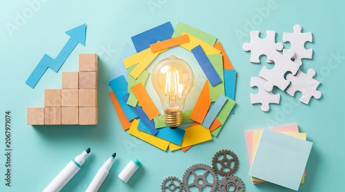 Bright innovation concept featuring a glowing light bulb surrounded by colorful geometric paper elements. Represents creativity, idea generation, brainstorming, innovation, and business development.