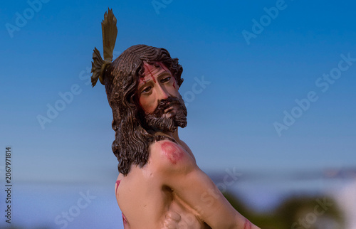Konstfotografi Religious statue of Jesus Christ with wounds against a clear blue sky