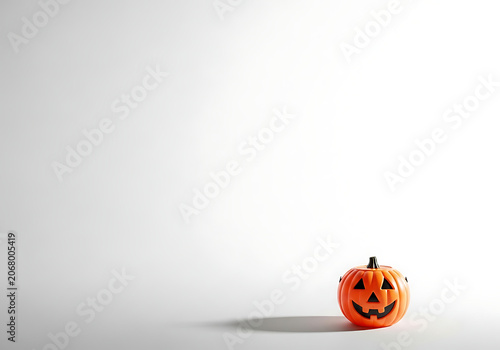 Minimal Halloween decoration with single plastic pumpkin on white background