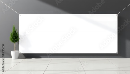 A small potted tree sits next to a large blank white sign on a gray wall with a tiled floor